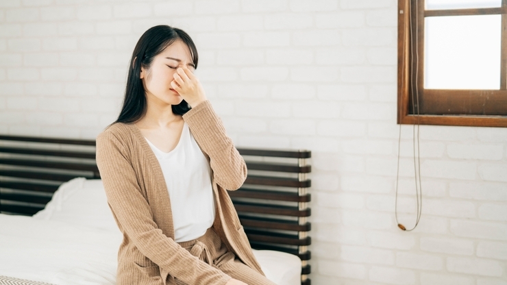 鼻を抑える女性