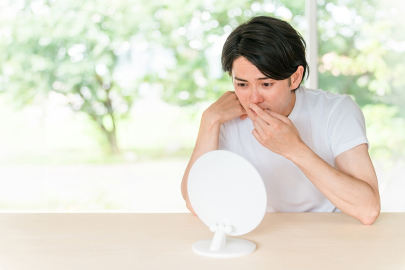 鼻を見つめる男性